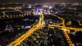 Spectacular aerial night view of illuminated highway interchange and urban skyline in Nanjing Jiangbei district, China with flowing traffic light trails - Powered by Shutterstock - Get 15% off with code: PIKWIZARD15