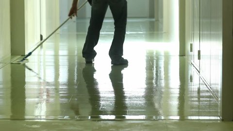 A man cleaning and wipes the floor with a rag