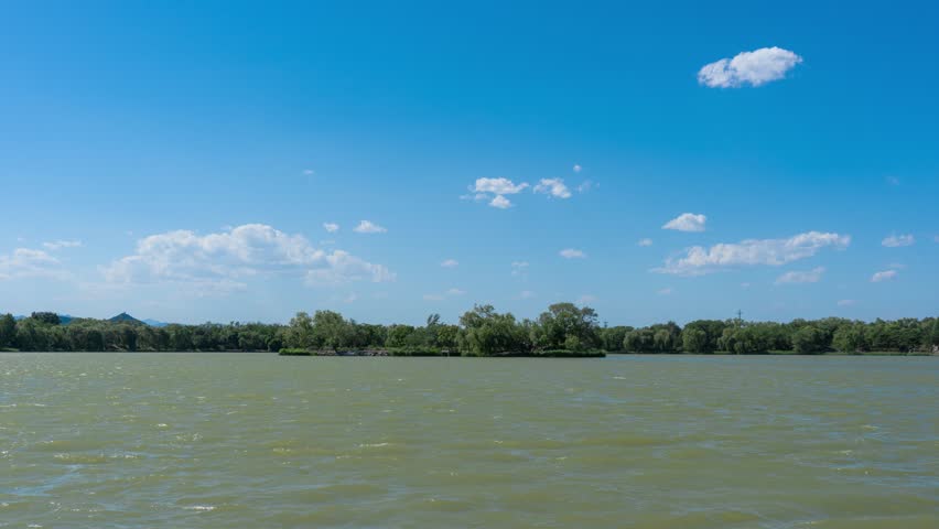 Scenic lake view with blue sky and white clouds at Yuanmingyuan (Old Summer Palace) in Beijing, China, perfect for nature and travel content.