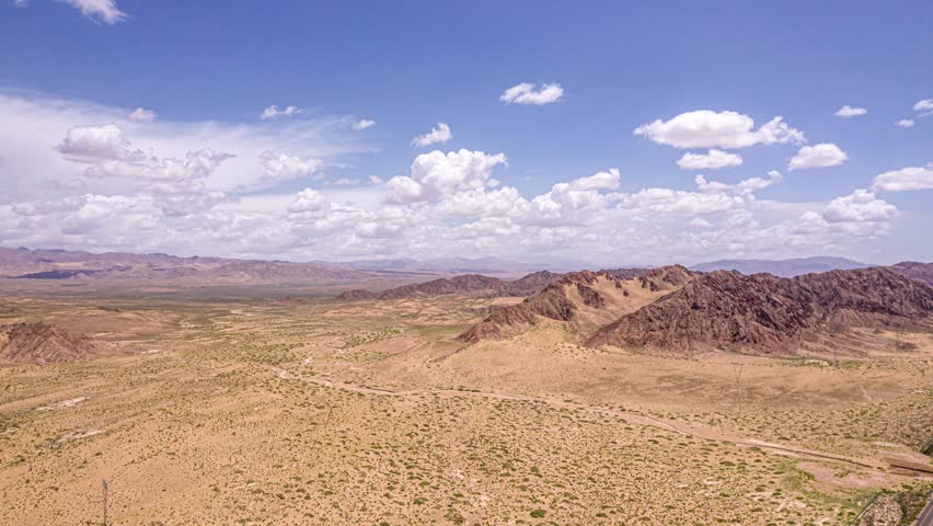 Vast Tibetan plateau desert landscape with endless barren terrain, rocky mountains, and dramatic cloudy sky perfect for time lapse photography