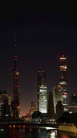 Shanghai Lujiazui skyline at dawn with illuminated skyscrapers including Oriental Pearl Tower and Shanghai Tower under starry sky, vertical composition