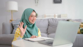Asian Muslim woman student learning online class in living room at home. Beautiful girl wearing hijab sit on floor, using digital laptop computer study courses by virtual remote online in cozy house. - Powered by Shutterstock - Get 15% off with code: PIKWIZARD15