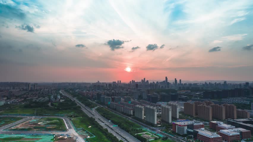 Stunning aerial view of Nanjing city skyline during golden hour sunset with dramatic clouds and urban landscape stretching to the horizon in China.