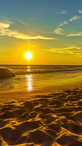 Timelapse of a serene sunset over the ocean with calm waves on sandy beach