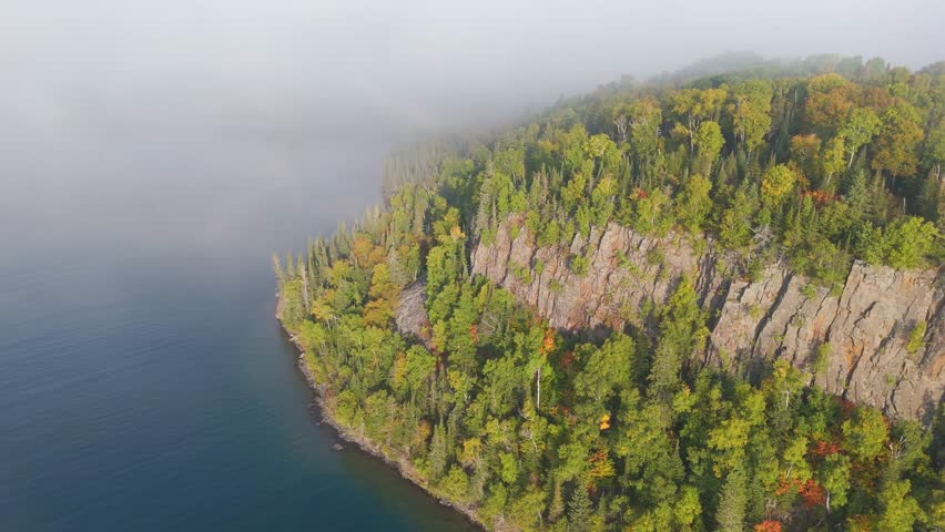 Vertical cliff and forest during early autumn at Lake Superior shoreline in Ontario, Canada.