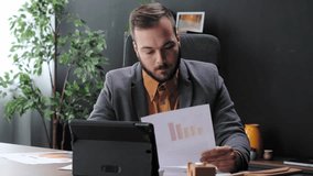 Professional businessman analyzing sales charts and data on documents and a tablet in the office - Powered by Shutterstock - Get 15% off with code: PIKWIZARD15