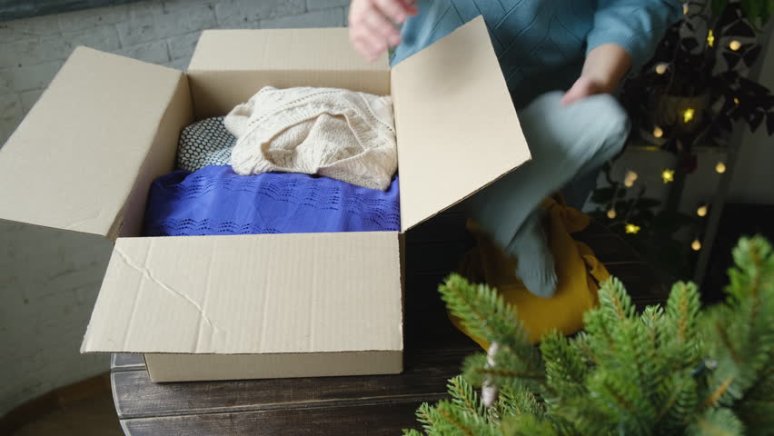 Christmas donation, charity concept. Woman contributes items for Christmas charitable donation