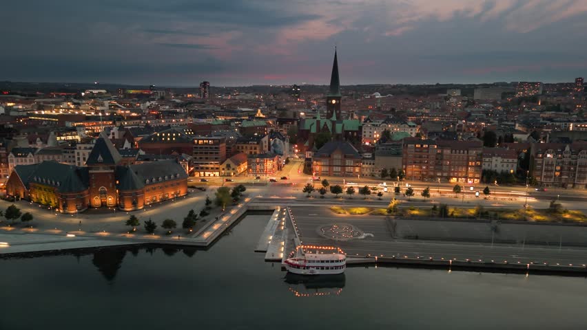 Aerial view of stunning skyline of Aarhus during sunset as the city lights twinkle. Evening shot of Aarhus embankment, Denmark