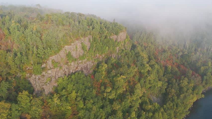 Autumn colors popping on a forest in Ontario, Canada. Morning with fog Aerial view