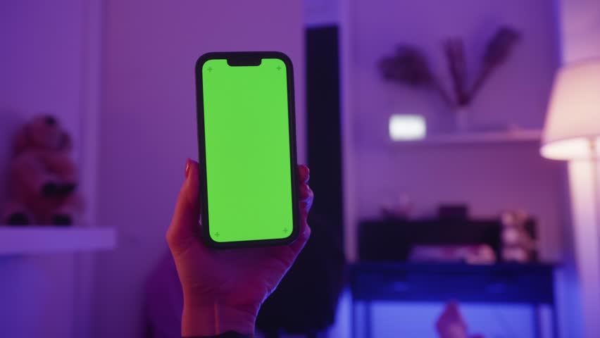 A woman lies on the bed and holds a phone with a green template. A man is resting in a modern apartment. Concept of leisure. High quality 4k footage