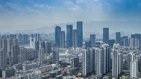 Aerial view of Minjiang River area with modern CBD skyline under blue sky with white clouds, showcasing urban development and mountain backdrop in natural daylight. - Powered by Shutterstock - Get 15% off with code: PIKWIZARD15