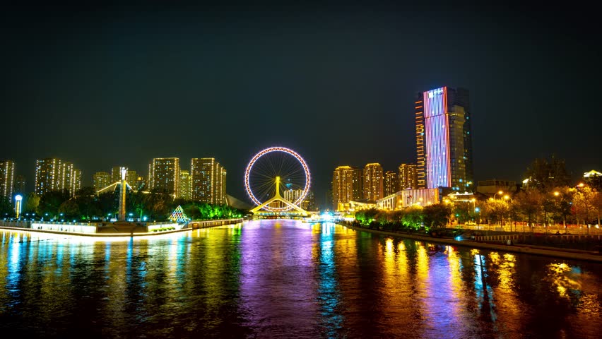 Stunning night view of Tianjin Eye ferris wheel and illuminated skyline reflecting in Haihe River, China. Perfect time-lapse photography showcasing vibrant city lights and architecture.