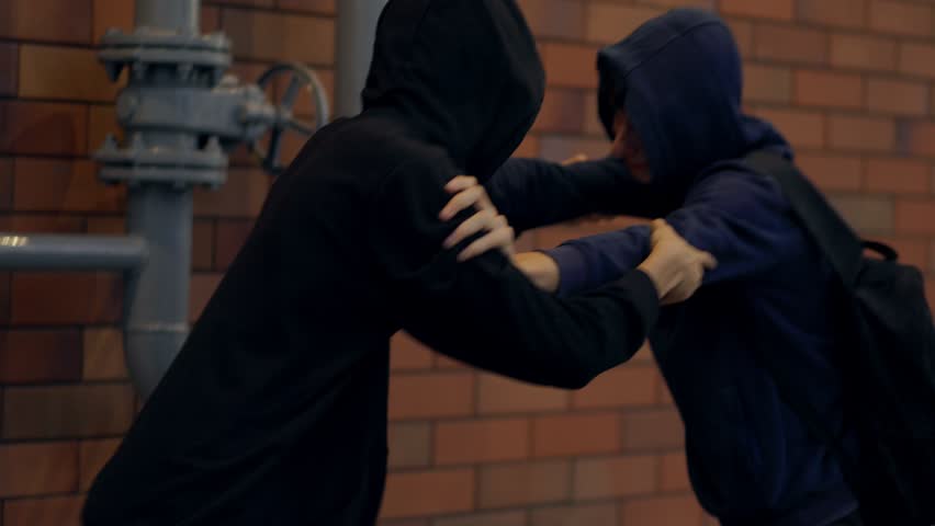 A tense urban street fight shows two young boys in hoodies clashing violently at night, symbolizing crime, fear, aggression, and rising social issues.