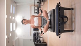Instructor woman doing arm exercises on pilates reformer machine.Vertical video - Powered by Shutterstock - Get 15% off with code: PIKWIZARD15