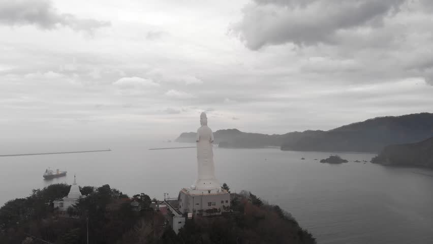 Aerial establishing at Misty Aizu Jibo Dai Kannon Statue in Japanese Lush Mountain Lake Landscape