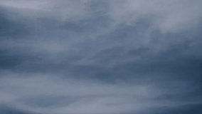 A panning video showing bright and dark layers of clouds over a muted blue-gray sky, illustrating moody atmospheric transitions in nature. - Powered by Shutterstock - Get 15% off with code: PIKWIZARD15