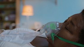Close up shot of hands of unrecognizable nurse adjusting oxygen mask on face of senior sick woman resting at home - Powered by Shutterstock - Get 15% off with code: PIKWIZARD15