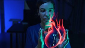 female doctor sitting looking at a heart hologram using a digital cardiology interface displaying a human heart to research heart disease in a hospital. Concept of technological development treatment  - Powered by Shutterstock - Get 15% off with code: PIKWIZARD15