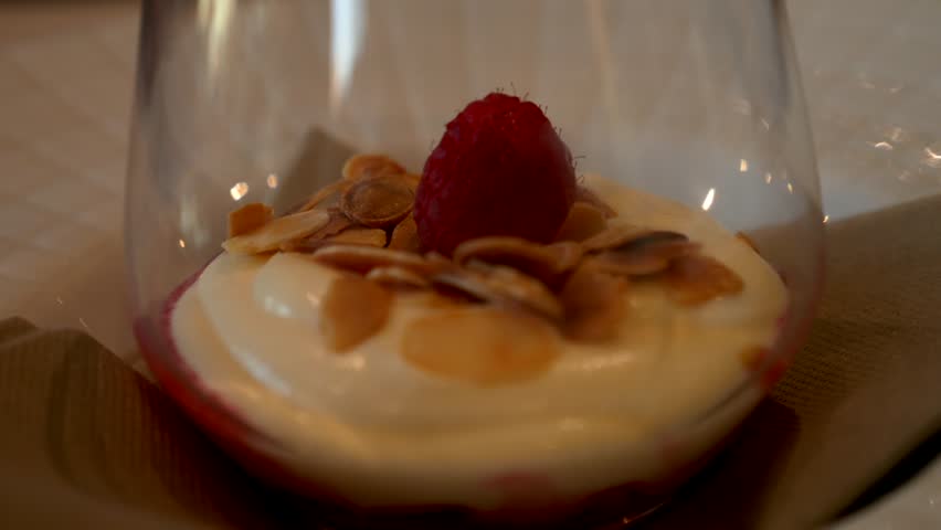 Close up raspberry dessert with cream in a glass. Panning 4K