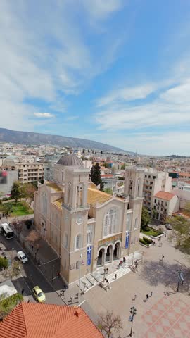 Cinematic FPV drone flight over the Metropolitan Cathedral of Athens, Greece, revealing the Acropolis hill and historic cityscape on sunny day.
