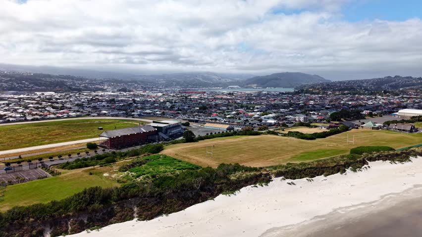 Incredible rapid drone reveal of beautiful coastal City Dunedin and its commercial harbour,New Zealand on beautiful sunny summers day