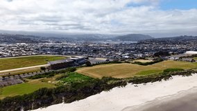 Incredible rapid drone reveal of beautiful coastal City Dunedin and its commercial harbour,New Zealand on beautiful sunny summers day - Powered by Shutterstock - Get 15% off with code: PIKWIZARD15