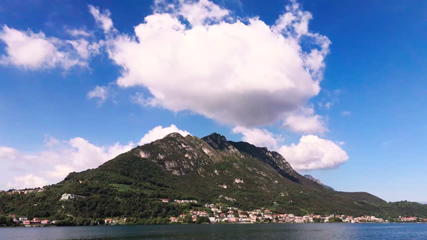 Fly sideways, view of big cloud over mountain at Lake Garlate, Italy