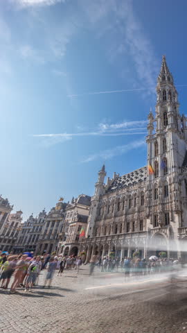 Timelapse hyperlapse of Town Hall (Hotel de Ville) on the Grand Place in Brussels, Belgium. Looking up at the Gothic tower and facade. A UNESCO World Heritage Site and major tourist destination