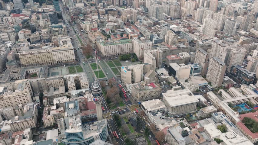 Drone footage showing Torre Entel and La Moneda Palace surrounded by city streets and historic buildings in central Santiago, Chile