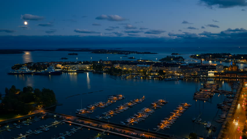 Aerial hyperlapse over Pohjoisranta, toward the moon above the sea of Helsinki