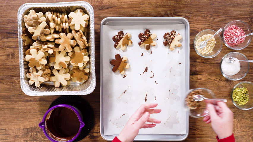 Flat lay. Preparing star-shaped cookies, half-dipped in chocolate, accented with peppermint chocolate chips for the holidays.