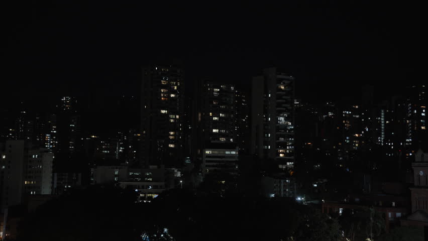 The city skyline of Medellín at night, towers glowing in neon and citylights, Colombian night