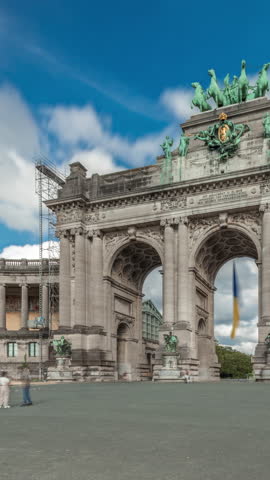 Hyperlapse of the Cinquantenaire Arcade in Jubelpark, Brussels, Belgium. The memorial triumphal arch stands tall under dramatic clouds timelapse, symbolizing Belgian history and independence.