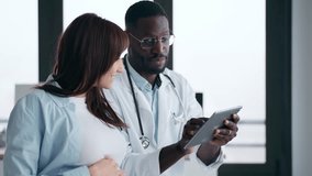 Video of cheerful gynecologist doctor showing to pregnant woman ultrasound scan baby with digital tablet in medical consultation - Powered by Shutterstock - Get 15% off with code: PIKWIZARD15