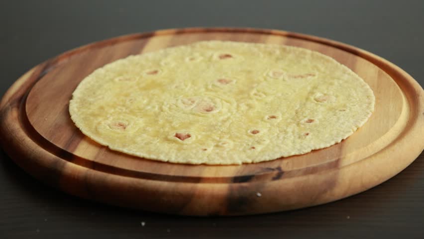 corn tortillas folding on wooden cutting board close up