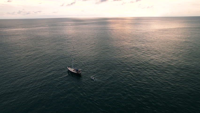 Aerial view of a sailing yacht at sunset