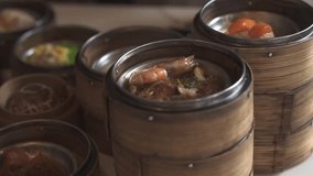 A close-up shot of various dim sum dishes served in traditional bamboo steamers at Dim Sum restaurant. Cinematic lighting. Delicious dim sum, Chinese food. - Powered by Shutterstock - Get 15% off with code: PIKWIZARD15