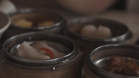 A close-up shot of various dim sum dishes served in traditional bamboo steamers at Dim Sum restaurant. Cinematic lighting. Delicious dim sum, Chinese food. - Powered by Shutterstock - Get 15% off with code: PIKWIZARD15