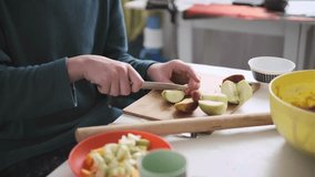 Teenager slicing apples, preparing fruit ingredients for homemade apple-pumpkin pie. Part of series - Powered by Shutterstock - Get 15% off with code: PIKWIZARD15