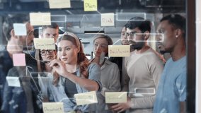Diverse team of professionals brainstorming around glass board with sticky notes labeled plan, analysis, and product. Holographic diagrams and digital interface overlays showing strategy visualization - Powered by Shutterstock - Get 15% off with code: PIKWIZARD15