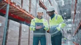 Two male engineers wearing helmets and reflective jackets standing in warehouse. People holding tablet device with digital data projection. Workers analyzing inventory and discussing logistics. - Powered by Shutterstock - Get 15% off with code: PIKWIZARD15