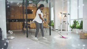 African American woman cleaning floor with mop while holding smartphone displaying digital interface. Female using smart home app in bright modern apartment with wooden kitchen interior. - Powered by Shutterstock - Get 15% off with code: PIKWIZARD15