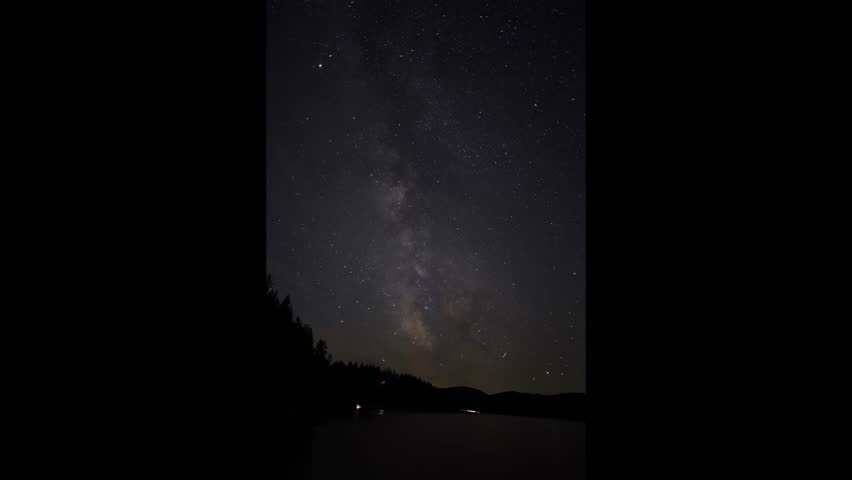 Timelapse of Milky Way stars moving across the night sky above Lake Roosevelt in Colville, Washington, highlighting vibrant celestial colors and tranquil reflections.
