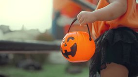 B roll - Close up of little child holding orange jack o lantern bucket during Halloween festival, kid wearing pumpkin costume outdoors, autumn holiday celebration concept with festive atmosphere - Powered by Shutterstock - Get 15% off with code: PIKWIZARD15