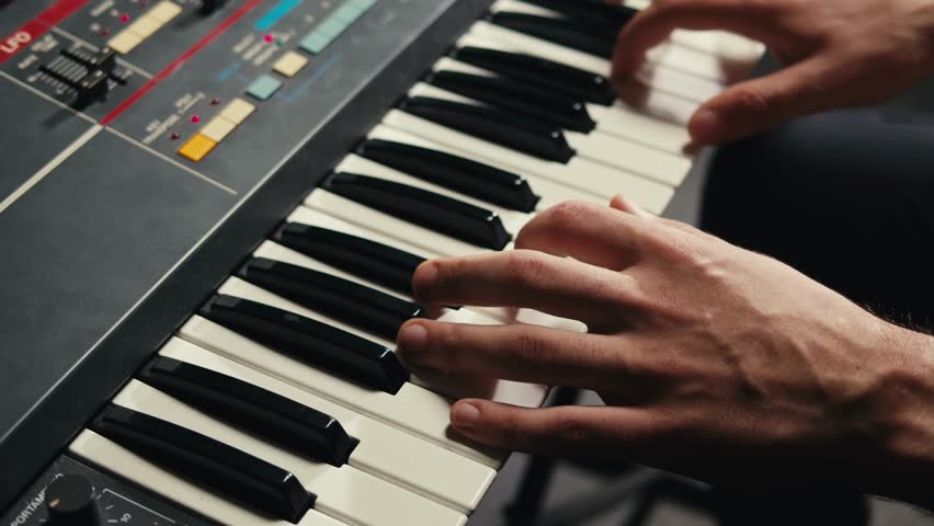 Playing piano vintage retro synthesizer. Close up of man hands playing jazz on the piano. Fingers on the piano, vintage colors. A very close look at a jazz pianist hands. Man playing the piano, close