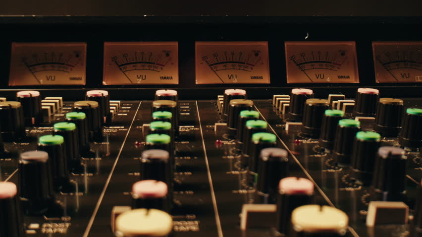 Music studio close up, Close up hands shot of sound engineer using mixing console, remote control for adjusting sound, audio mixer. Musician creates music, makes remix for DJ set. Sound recording