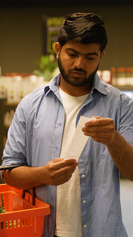Man shocked by high grocery prices reading receipt