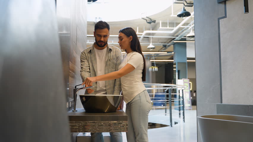 Just married couple choosing new bathroom sink in a showroom on Black Friday