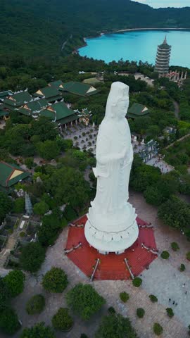 religious Lady Buddha monument at Linh Ung pagoda and buddhism temple, Asian religion and spirituality, Son Tra peninsula, Da Nang, Vietnam 4k aerial drone view, vertical video