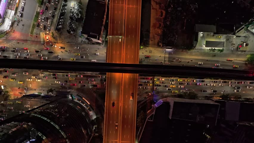 Top down view of city traffic flowing through nighttime Bangkok Thailand
